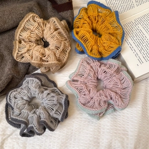 Macro view of four knit crochet scrunchies with vibrant borders and rich hollow textures