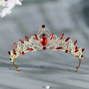 Détails de la couronne baroque dorée avec cristaux rouges et motifs de vignes ajourées