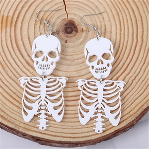 Gothic punk white skeleton earrings for Halloween party outfits on a wooden background
