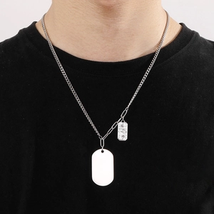 Gros plan d'un collier en acier titane argenté avec plaque militaire et pendentifs