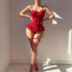 Détail d'un corset en dentelle rouge avec laçage croisé et bas résille assortis