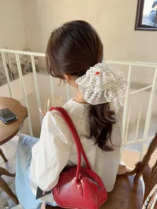 Detail showing white polka dot ruffled scrunchie with red heart handmade label