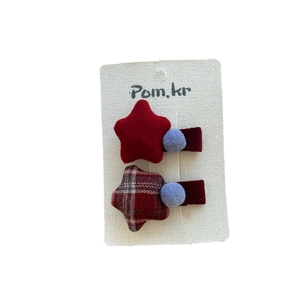 Cute red star-shaped hair clips set with pom poms for children and girls