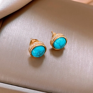 Macro shot of gold-plated turquoise earrings with micro-set zircon in a vintage style