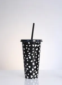 Detailed view of a black reusable straw cup featuring a white heart pattern print