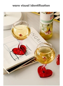 Close-up of wine glass with romantic pink twisted stem and red heart-shaped base