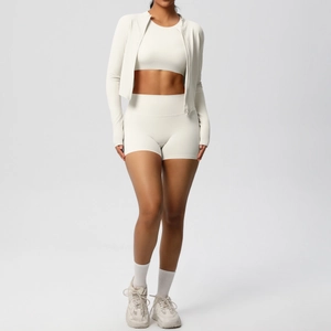 Dettaglio di un set yoga tre pezzi bianco crema con giacca, top e pantaloncini sport