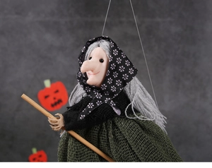 Detail of a Halloween witch doll hanging decoration with grey hair and wooden broomstick