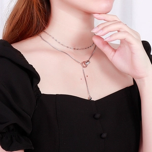 Detail of silver double-layered Y-necklace with interlocking rings and bead pendant