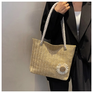 Macro view of woven straw tote bag texture with white rope handle and daisy flower detail
