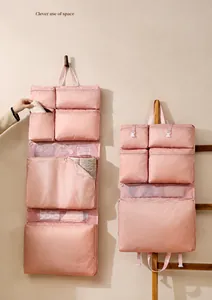 Dettaglio dell'organizzatore da viaggio pieghevole rosa con scomparti in rete e gancio