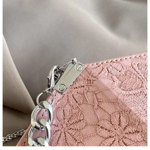 Detail of pink embroidered leather handbag with silver chain and floral pattern