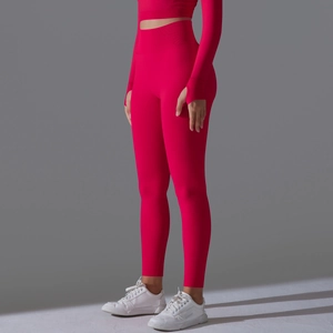Detail view of red seamless yoga leggings with wide ribbed waistband and thumbhole sleeves