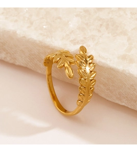 Detailed view of adjustable golden leaf ring on white stone, minimalist nature jewelry