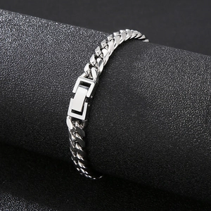 Macro shot of silver titanium steel Cuban link bracelet on a textured display stand