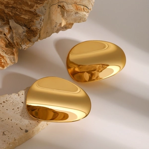 Polished gold irregular pebble earrings shown on textured natural stone background