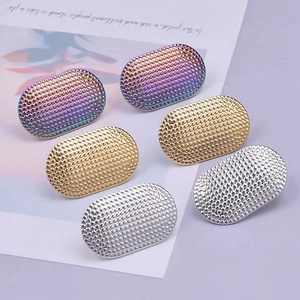 Macro shot of oval textured steel earrings in rainbow, gold, and silver finishes