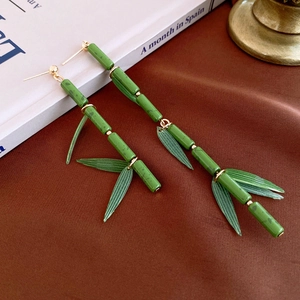 Modern resin bamboo drop earrings in vibrant green with golden metal accents
