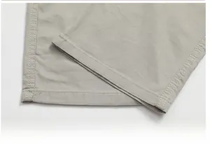Detailaufnahme der grauen Cargohose mit geradem Saum und weißen Doppelsteppnähten