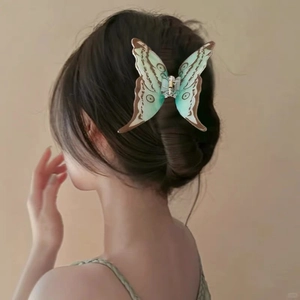 Détail de la pince à cheveux papillon géante avec dégradé vert menthe dans les cheveux