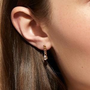 Close-up of elegant gold chain drop earrings with clear water-drop zirconia on model