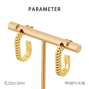Detail view of gold U-shaped earrings with textured brick pattern and size labels