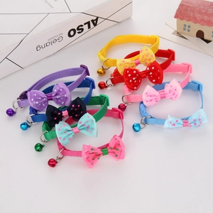 Close-up of colorful polka dot bow pet collars with bells in multiple colors