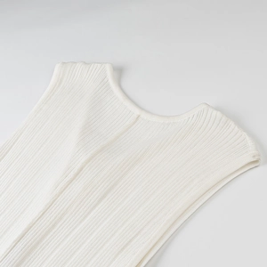 Close-up of ivory ribbed knit fabric showing the deep V-neckline and shoulder details