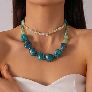 Detail of double-layer necklace with green resin beads and marble texture on neck