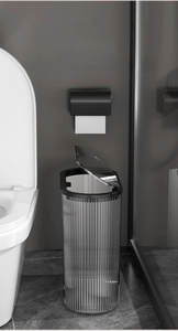 Close-up of slim translucent trash can with vertical stripes in a modern bathroom