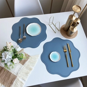 Blue petal-shaped faux leather placemats set for modern dining table decoration