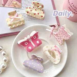 Detail view of cute macaron hair clips with silk bows and floral patterns on books