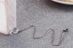 Detail of silver titanium chain with spherical glass crystal pendant and lobster clasp