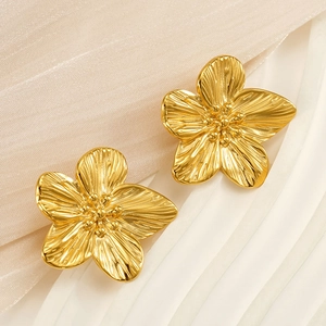 Macro view of golden flower stud earrings with textured petals and delicate center beads