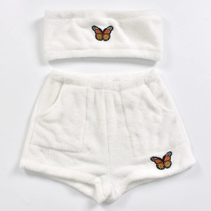 Détail d'un ensemble deux pièces blanc duveteux avec texture douce et broderie papillon