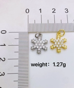 Macro scale shot showing gold and silver snowflake pendants with zircons weighing 1.27g