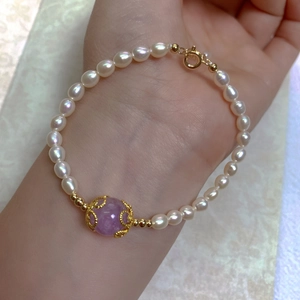 Detailed shot of baroque freshwater pearl bracelet with ornate purple gemstone bead