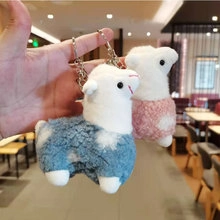 Detail of soft plush sheep keychains in blue and pink with cute white cloud patterns