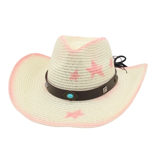 Détail des motifs d'étoiles roses et de la pierre turquoise sur chapeau de paille