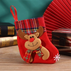 Detail of red knit Christmas stocking with 3D reindeer and red-black plaid trim
