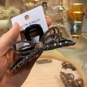 Detail of elegant bow hair claw clip with sparkling black and clear rhinestones