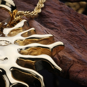 Vue macro d'un pendentif soleil doré vintage sur un fond en bois sombre texturé