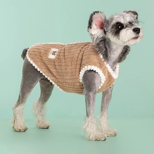 Warm fleece dog vest in brown plush fabric with white pom-pom trim for winter