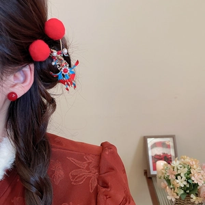 Close-up of New Chinese style hair clip with red pom-poms and phoenix enamel details