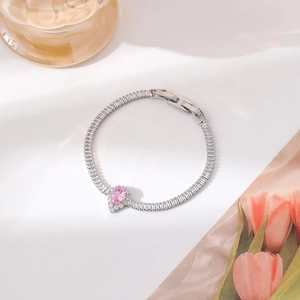 Macro shot of a silver bracelet featuring a pink teardrop zircon and pavé crystals
