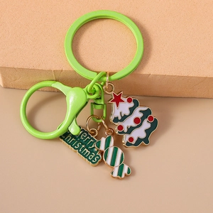 Detail of Christmas tree, candy cane, and Merry Christmas enamel pendants on green keychain