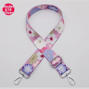 Detail of floral pink wide bag strap with silver metal swivel hooks and buckles