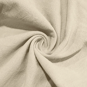 Macro view of light cream linen fabric showing soft texture and breathable woven pattern
