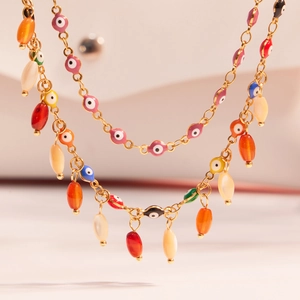 Gold layered necklace featuring colorful evil eye beads and agate stone tassels
