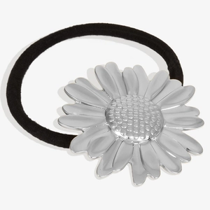 Detailed close-up of a silver daisy charm on a black elastic hair tie with 304 steel